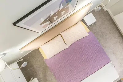 a table with two pillows on top of a purple rug at Art & Comfort Rooms in Kaunas