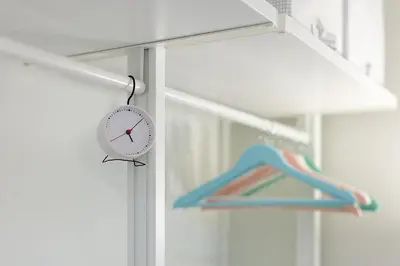 a clock hanging on a window next to a blue object at Art & Comfort Rooms in Kaunas
