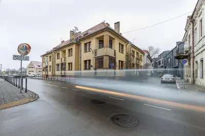 a car is driving down a city street with buildings at Art & Comfort Rooms in Kaunas