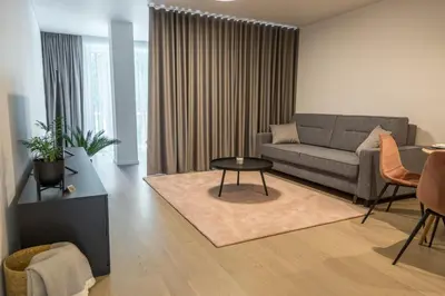 a living room with a couch and a table at Apartment Hotel Laisve in Druskininkai