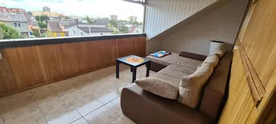 a small balcony with a couch and a table at Sauliaus apartamentai VIP in Panevėžys