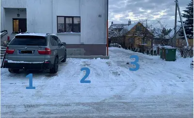 a car parked in a parking lot in the snow at Sauliaus apartamentai VIP in Panevėžys