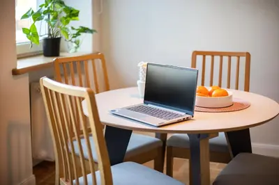 a laptop computer sitting on a table with a bowl of oranges at Art & Comfort Home in Kaunas