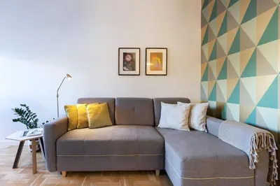 a living room with a gray couch with yellow pillows at Art & Comfort Home in Kaunas