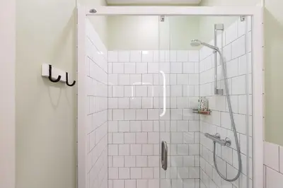 a bathroom with a shower with white tiles at Art & Comfort Home in Kaunas