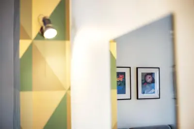 a hallway with two pictures on a wall and a mirror at Art & Comfort Home in Kaunas