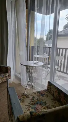 a living room with a chair and a table and a window at DP Art Residence - self check in in Kaunas