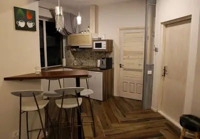 a small kitchen with a counter and stools in it at DP Art Residence - self check in in Kaunas