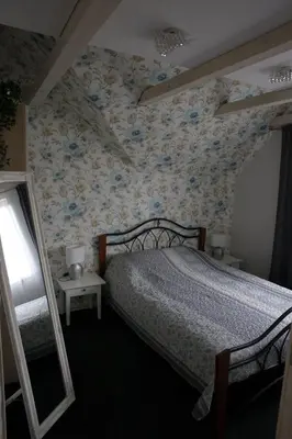 a bedroom with a bed with a floral wallpaper at DP Art Residence - self check in in Kaunas