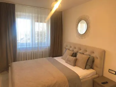 a bedroom with a bed with a mirror and a window at Trakų street Apartment in Šiauliai