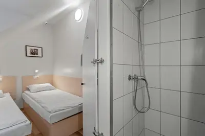 a bathroom with a shower and a bed at Stay Express in Vilnius
