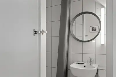 a white bathroom with a sink and a mirror at Stay Express in Vilnius