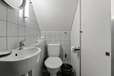 a white bathroom with a toilet and a sink at Stay Express in Vilnius