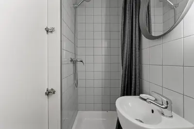 a white bathroom with a sink and a shower at Stay Express in Vilnius
