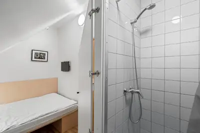 a bathroom with a shower with a bench in it at Stay Express in Vilnius