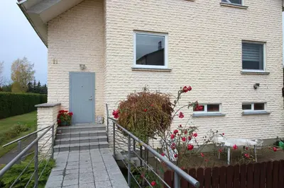 a house with a staircase leading up to a door at Dangus in Ramučiai
