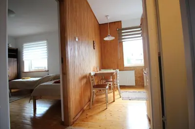 a living room with a table and a dining room at Dangus in Ramučiai