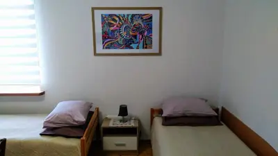 a bedroom with two beds and a picture on the wall at Dangus in Ramučiai