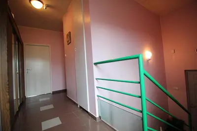 a hallway with pink and green walls and a staircase at Dangus in Ramučiai