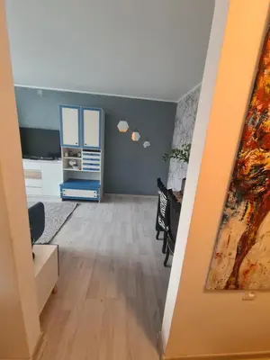 a living room with a desk and a dresser at Blue apartment in Šiauliai