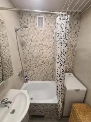 a bathroom with a white tub and a sink at Blue apartment in Šiauliai