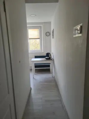an empty hallway with a desk and a window at Blue apartment in Šiauliai