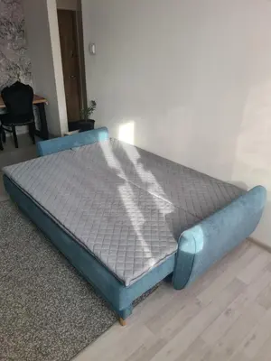 a blue bed sitting on a floor in a room at Blue apartment in Šiauliai