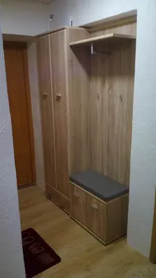 a room with wooden cabinets with a bench in it at Bright apartment on top in Panevėžys