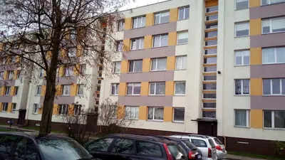 a group of cars parked in front of a tall building at Bright apartment on top in Panevėžys
