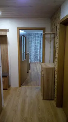 an empty room with wooden floors and a room with doors at Bright apartment on top in Panevėžys
