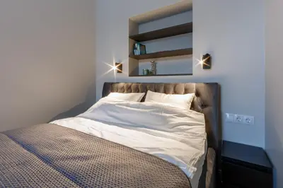 a bed with white sheets and pillows in a bedroom at Laisves ave. Apartments in Kaunas