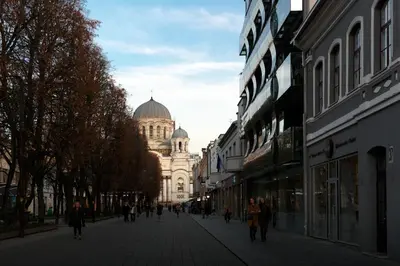 a street with a building in the distance with people walking on it at Laisves ave. Apartments in Kaunas