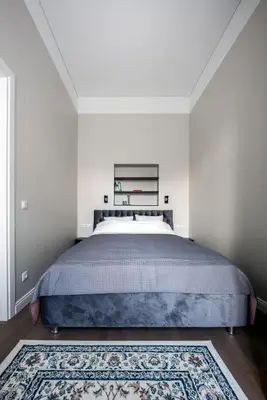 a bedroom with a large bed with a blue bedspread at Laisves ave. Apartments in Kaunas