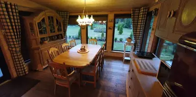 a kitchen with a wooden table and chairs in a room at Sauna2relax in Šveicarija
