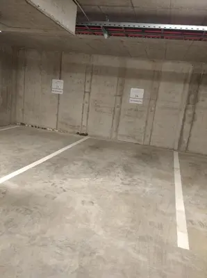 an empty parking garage with two signs on the wall at Mint Studio in Druskininkai