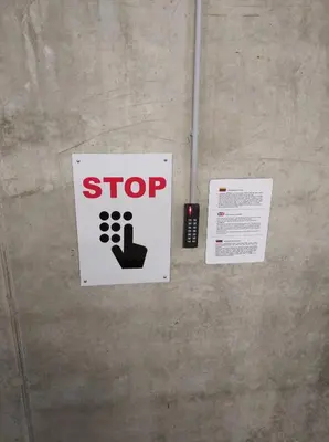 a stop sign on a wall with a pointing finger at Mint Studio in Druskininkai
