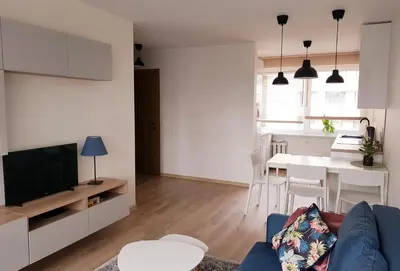a living room with a blue couch and a table at New CITY CENTER apartments in Druskininkai