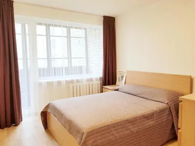 a bedroom with a bed and a large window at New CITY CENTER apartments in Druskininkai