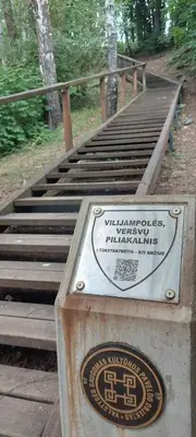 a set of wooden stairs with a sign on it at Raudondvario II in Kaunas