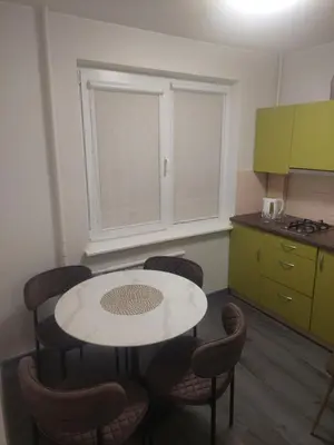 a kitchen with a table and chairs in a room at Kalniečiai park apartment in Kaunas