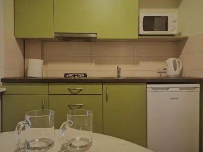 a kitchen with a table with two glasses on it at Kalniečiai park apartment in Kaunas