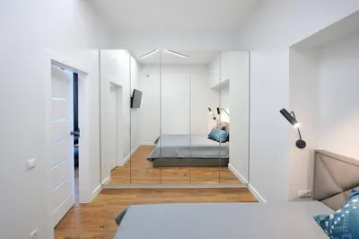 a bedroom with a bed and a hallway with a mirror at Šalia Kauno centro in Kaunas