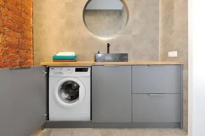 a laundry room with a washing machine and a mirror at Šalia Kauno centro in Kaunas