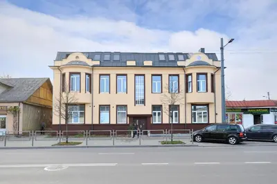 a large building with cars parked in front of it at Šalia Kauno centro in Kaunas