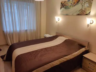 a bedroom with a bed and a window with a painting at Jaukus butukas in Druskininkai