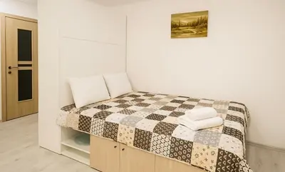 a bedroom with a bed with a checkered blanket at M&M Apartment I SELF CHECK-IN near Panevezys in Velžys