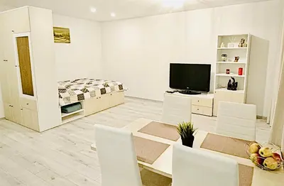 a white living room with a television and white chairs at M&M Apartment I SELF CHECK-IN near Panevezys in Velžys