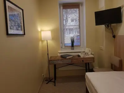 a room with a desk with a lamp and a window at Nėris Inn Terraces in Vilnius