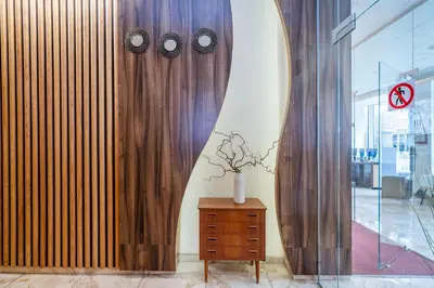 a room with a wooden wall with clocks on it at Nėris Inn Terraces in Vilnius