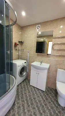 a bathroom with a washing machine and a washer at Anyksciai nakvyne in Anykščiai